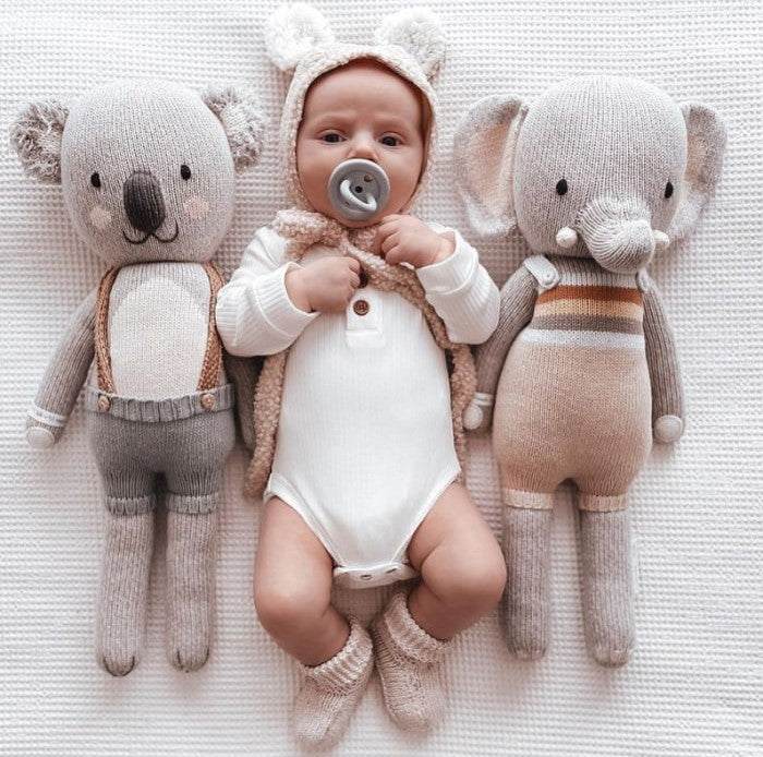 Baby with Hevea round natural rubber pacifier, BumiBebe, 0-3 months, cuddling plush toys.