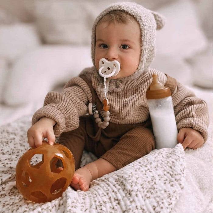 Hevea Star Ball made from natural rubber held by a baby, safe and flexible toy.