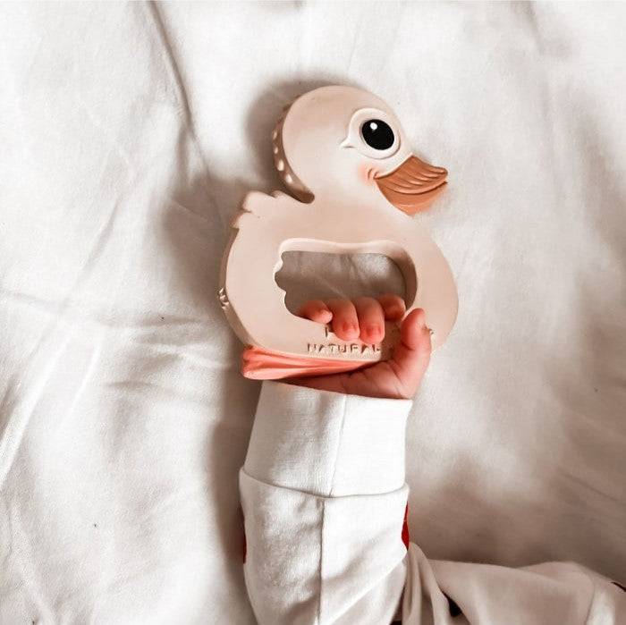 Hevea Kawan soothing gift set, natural rubber teether held by a child's hand.