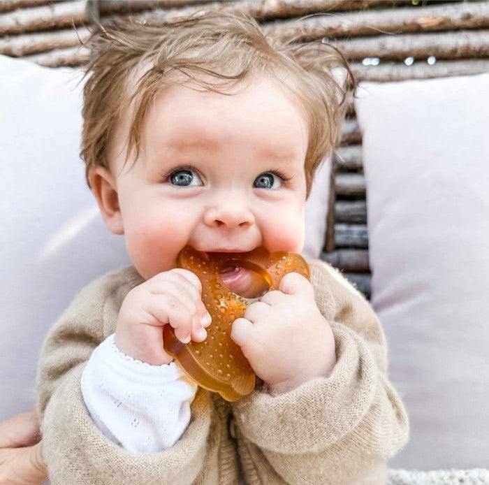 Baby using Hevea Bumibebe teether made from natural rubber, hygienic one-piece design.