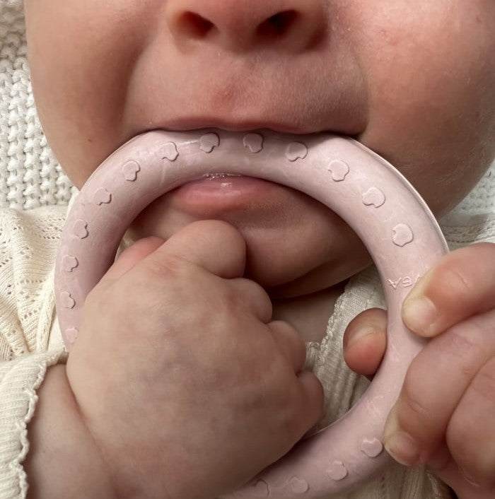 Baby using Hevea round teething ring made of natural rubber.