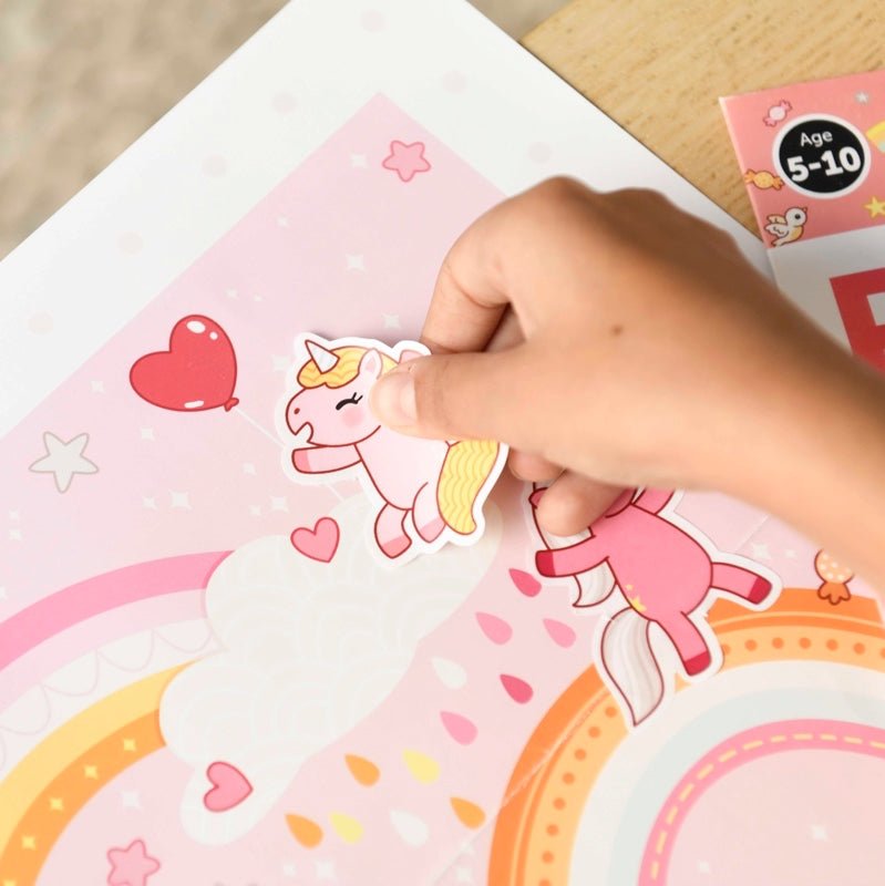 Child placing unicorn sticker on colorful Poppik Kreativni poster with reusable stickers.