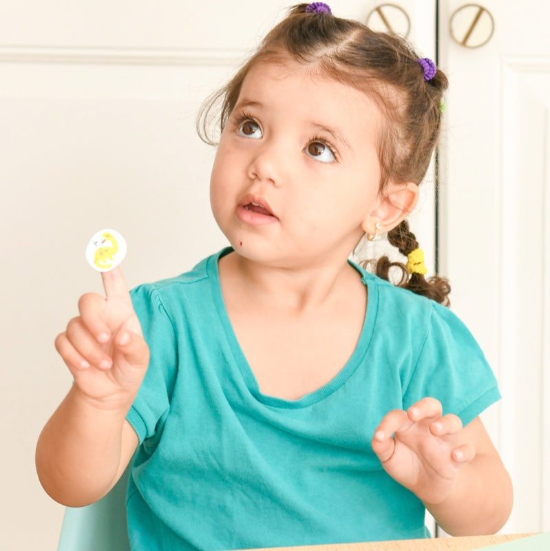 A young child interacts with Poppik Moje prve nalepnice, featuring easy-to-use, repositionable stickers, ideal for ages 2 and up.