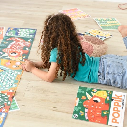 Poppik Panorama dinosaur sticker activity for kids 3+, girl engaged with stickers on large poster.