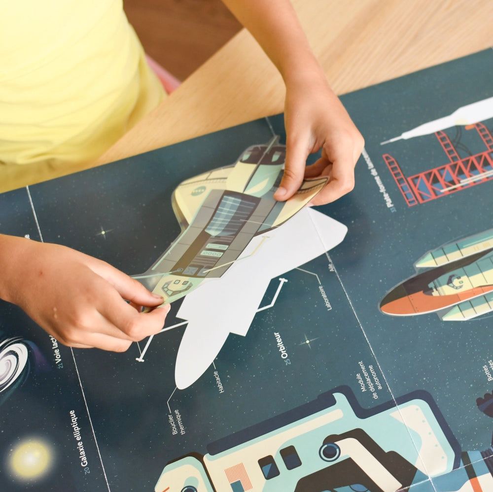 Child placing a sticker on an educational astronomy poster featuring planets, stars, and astronauts.