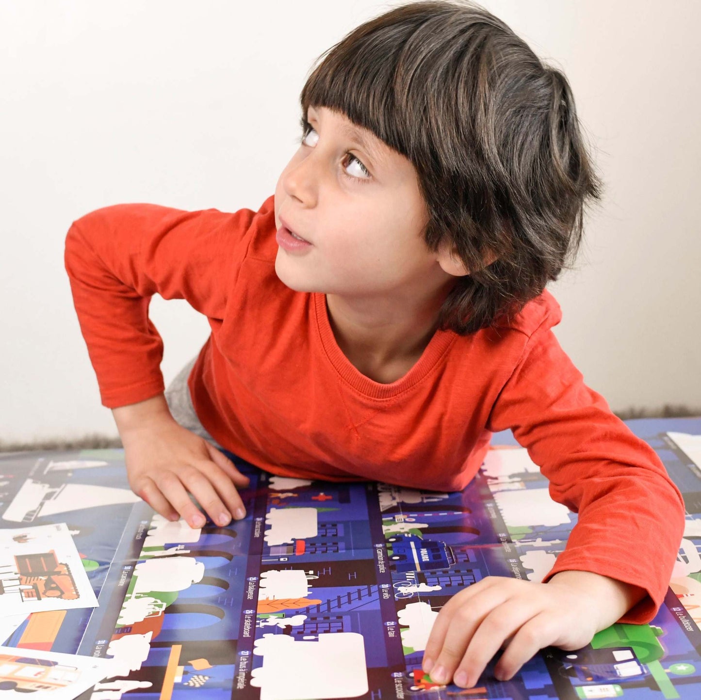 Child interacting with Poppik Edukativni poster Vozila with stickers.