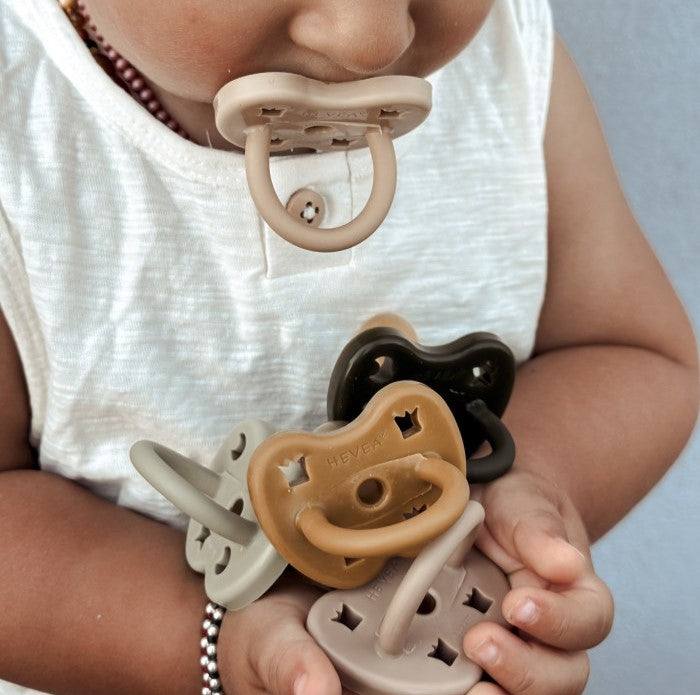 Hevea orthodontic pacifier made from natural rubber, designed for ages 3-36 months, shown in sand and skin colors.