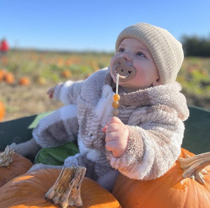 Baby using Hevea natural rubber pacifier, safe and gentle for infants aged 3-36 months.